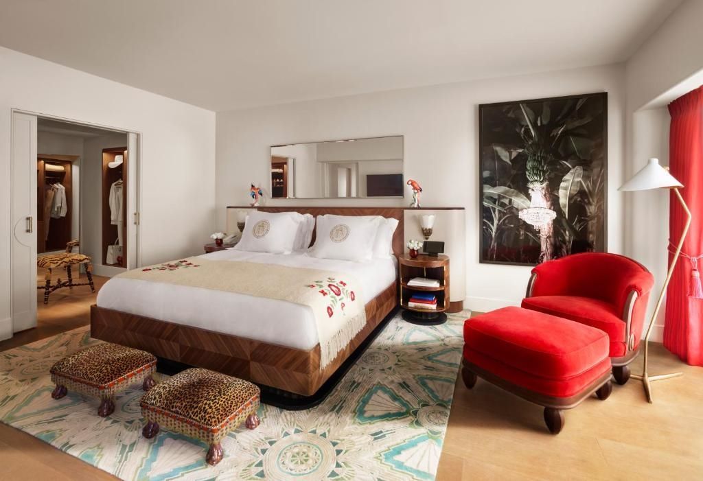 Elegantes Schlafzimmer in der Premier Corner Doppel Suite mit rotem Sessel.