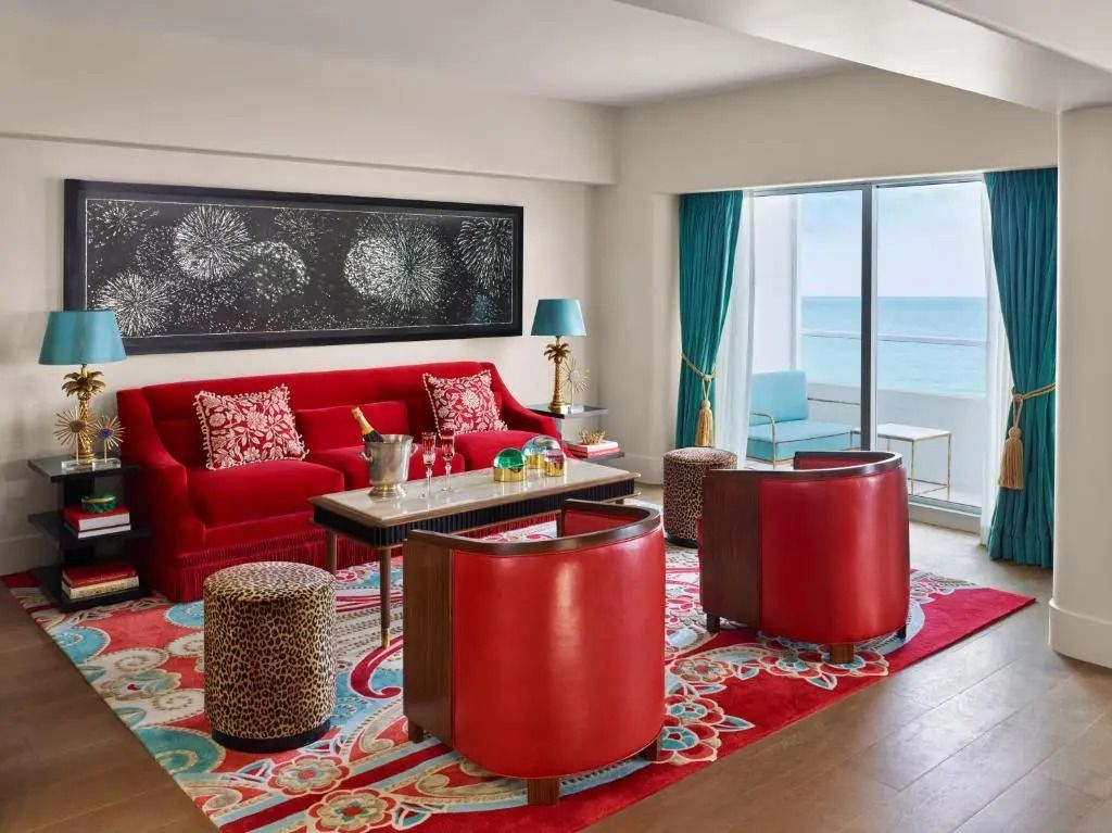Heller Wohnbereich mit rotem Sofa und Meerblick in der Junior-Suite