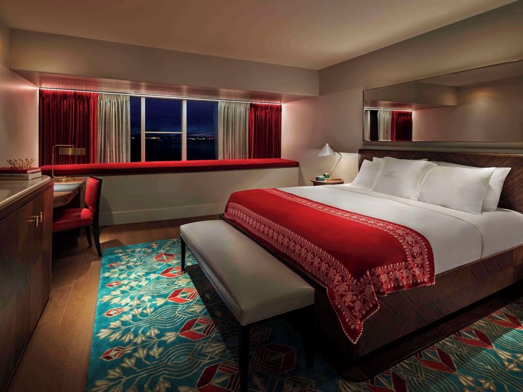 Elegantes Doppelzimmer mit rotem Farbschema und Blick auf die Bucht