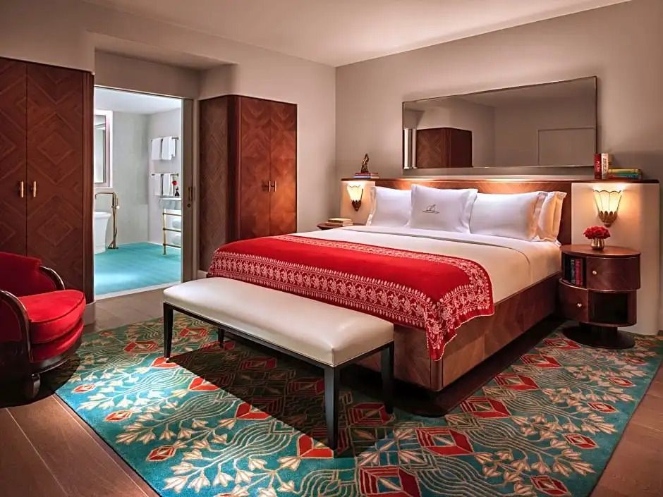 Hauptschlafzimmer in Suite mit rotem Überwurf und orientalischem Teppich