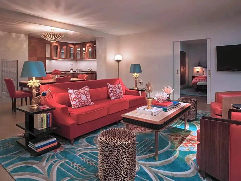 Gemütliches Wohnzimmer mit rotem Sofa und floralem Teppich