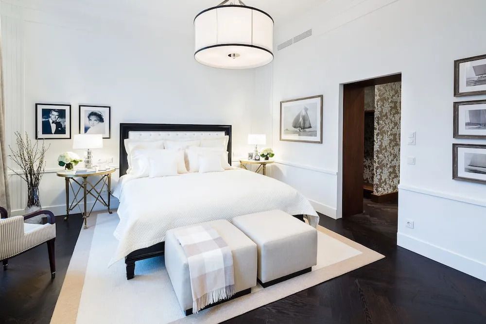 Elegantes Schlafzimmer mit weißem Doppelbett und stilvoller Beleuchtung