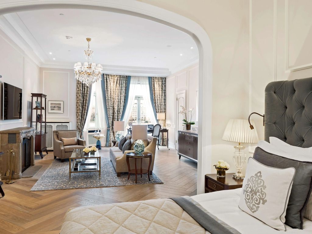 Elegantes Wohnzimmer einer Suite mit Kronleuchter und großen Fenstern