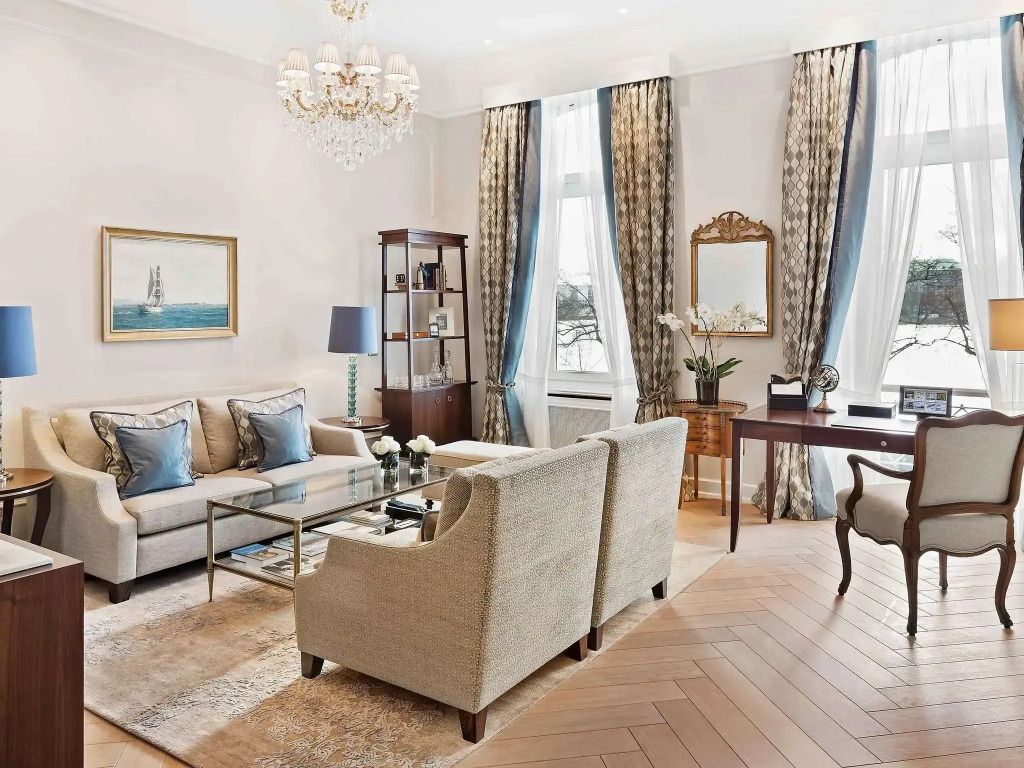 Wohnbereich einer Suite mit eleganten Möbeln und großem Fenster