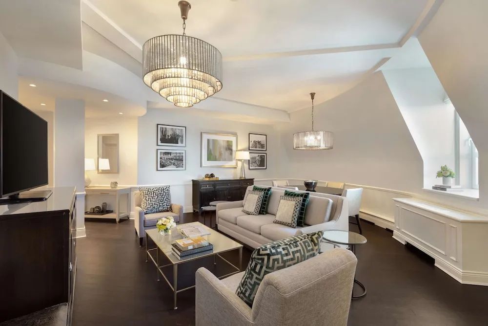 Großzügiger Wohnbereich mit stilvollen Sofas und kunstvollen Kronleuchtern in der Suite.
