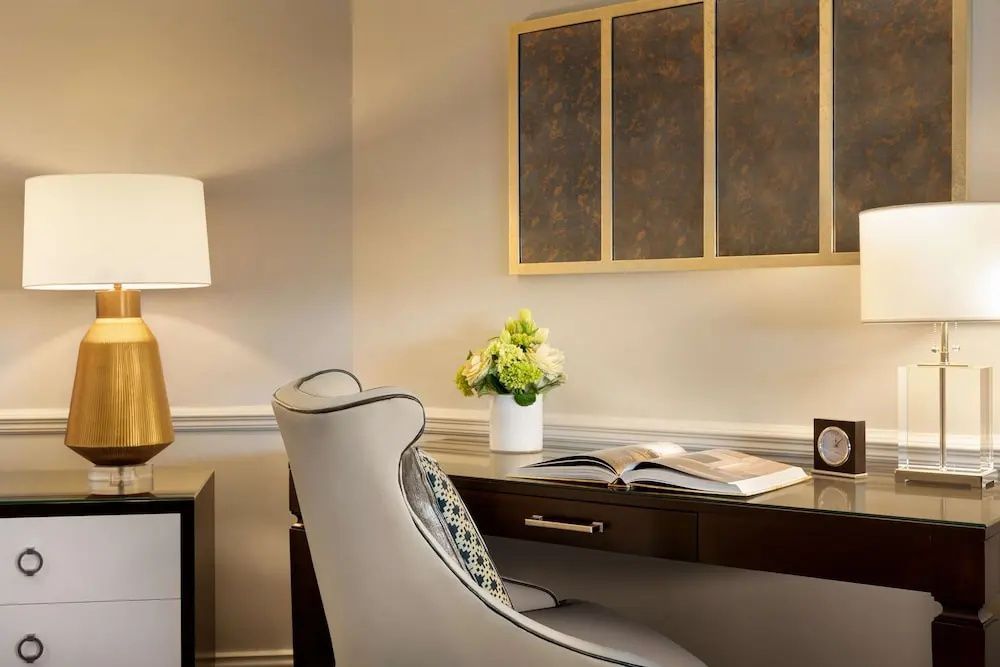 Schreibtisch mit komfortablem Stuhl und dekorativem Blumenarrangement in der Suite.