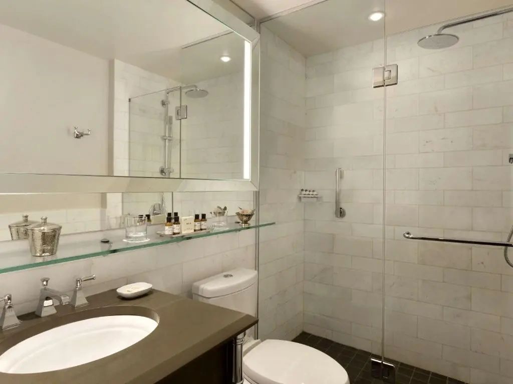 Modernes Badezimmer mit Dusche, Spiegel und eleganten Armaturen