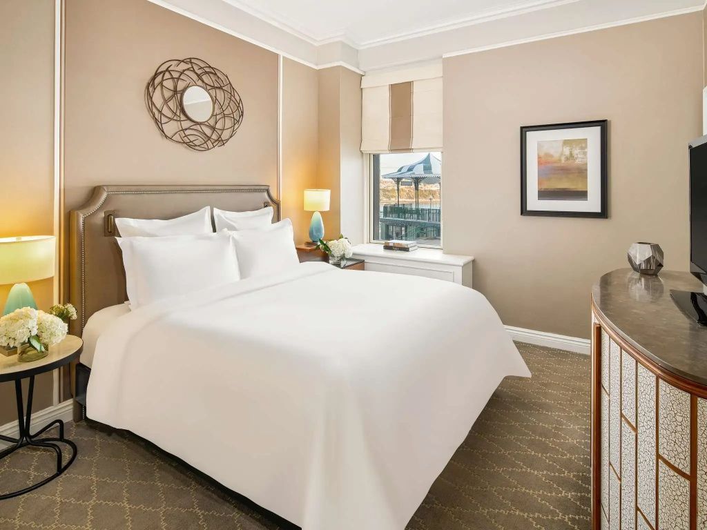 Helles Schlafzimmer mit Doppelbett und eleganter Wanddekoration