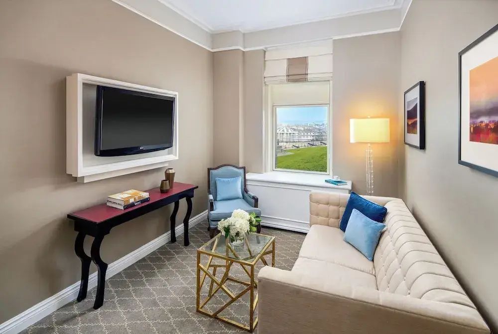 Gemütlicher Wohnbereich mit Sofa, Fernseher und Aussicht auf die Stadt