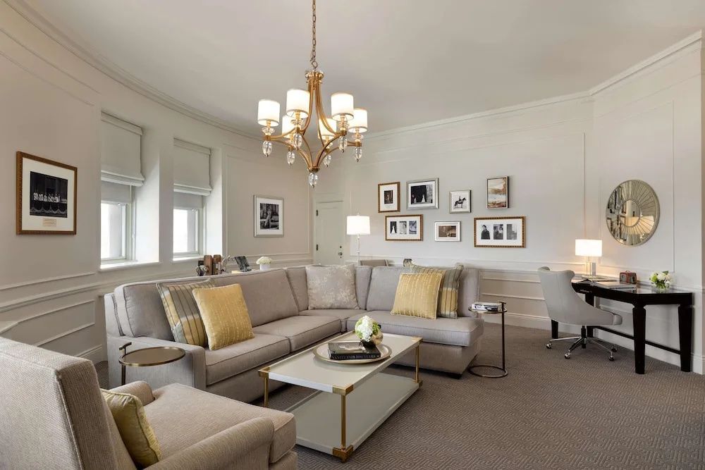 Geräumiges Wohnzimmer mit L-förmigem Sofa und prunkvollem Kronleuchter
