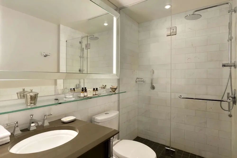 Modernes Badezimmer der Frontenac Suite mit großer Dusche und edlen Pflegeprodukten.