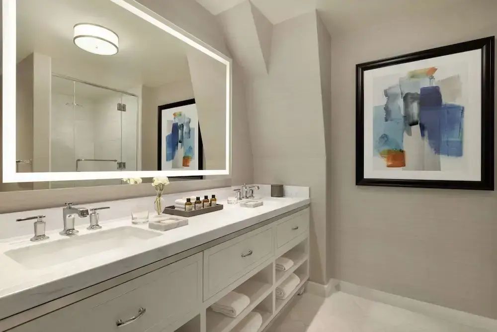 Modernes Badezimmer mit Doppelwaschbecken und stilvollen Armaturen in neutralen Tönen.