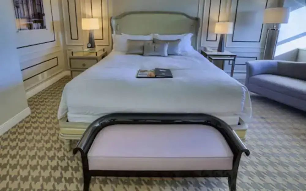 Einladendes Doppelbett mit eleganter Bettbank und Seitenlampen