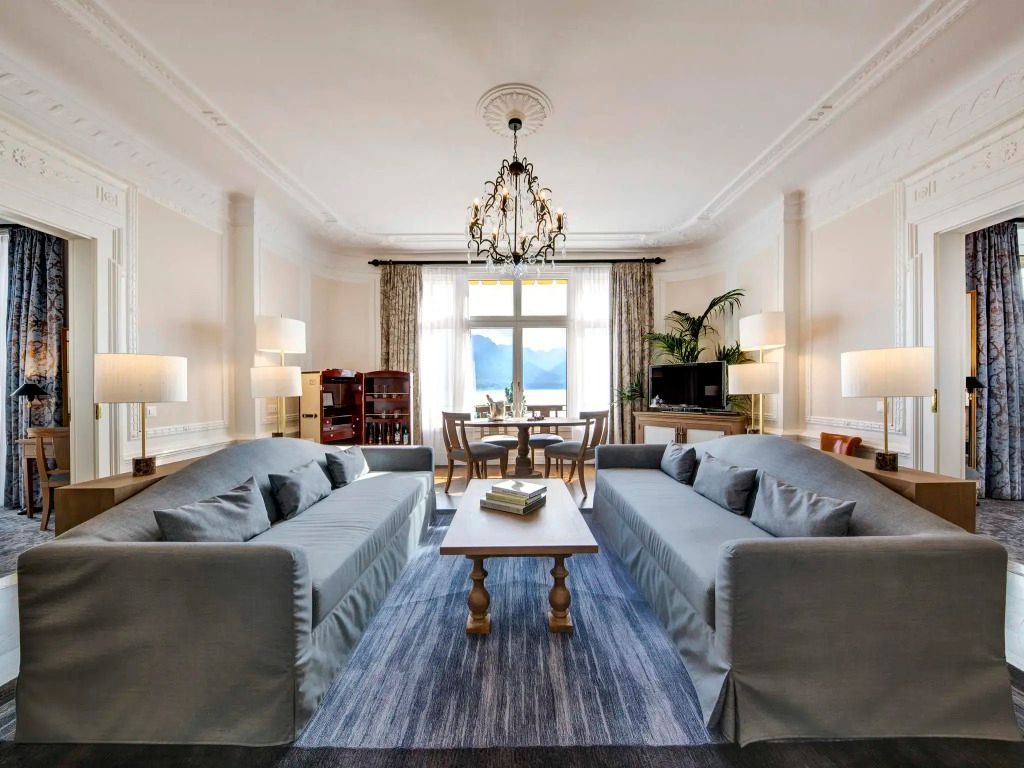 Großzügiges Wohnzimmer mit Sofas und Blick auf den See im Fairmont Le Montreux Palace