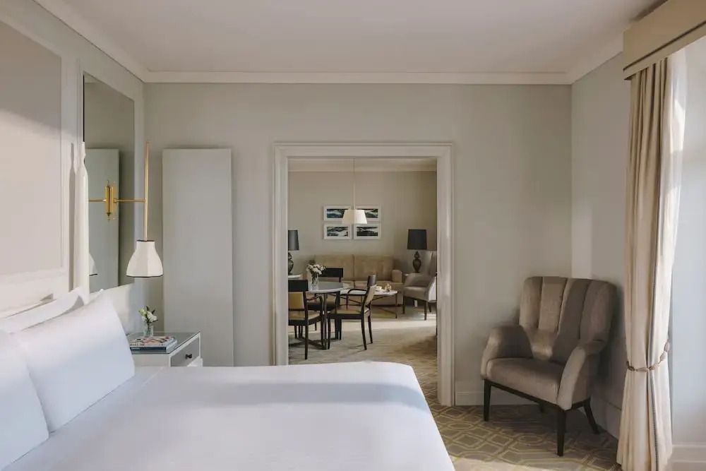 Blick vom Schlafzimmer in den Wohnbereich der Junior-Suite mit Sicht auf Sofa und Tisch.