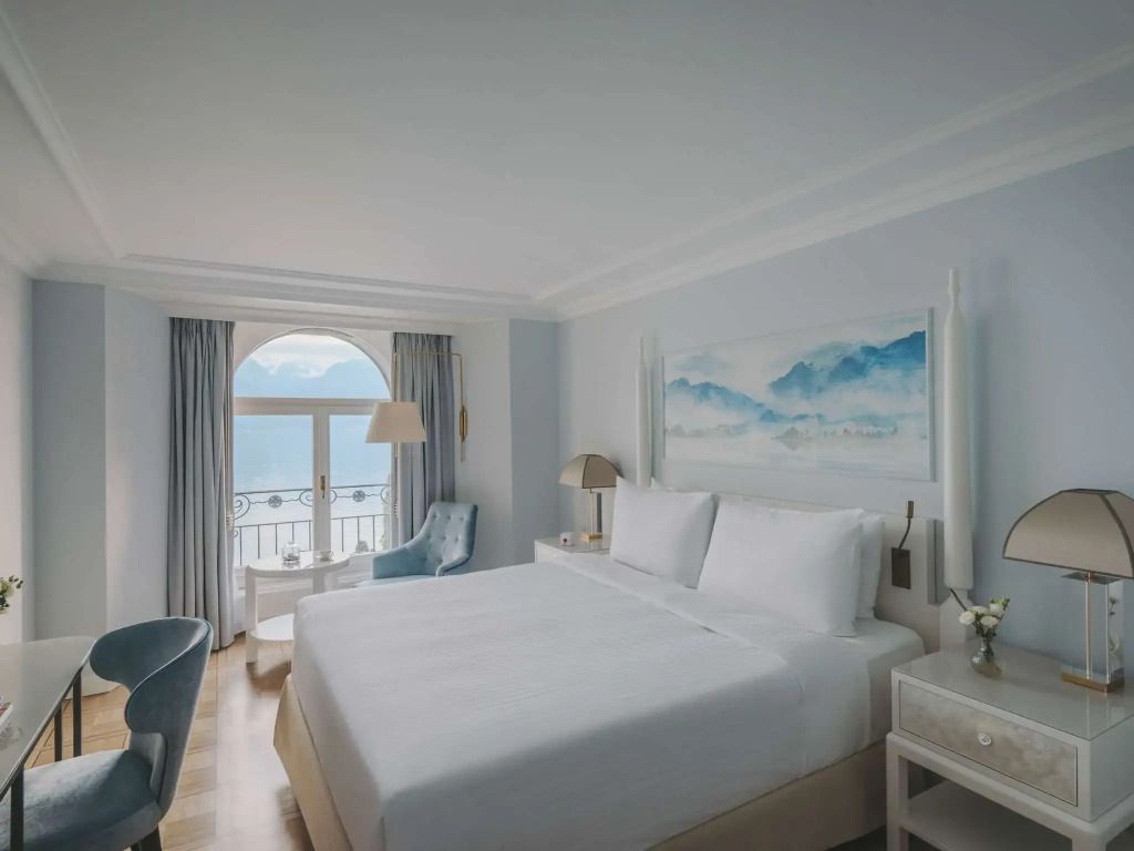 Helles Schlafzimmer im Fairmont Hotel mit großem Fenster und Seeblick.