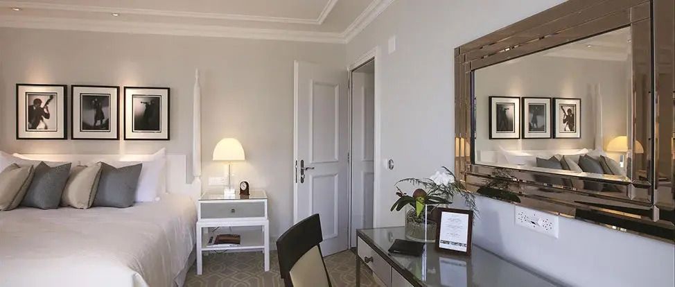 Elegantes Hotelzimmer mit Schreibtisch, Stuhl und dekorativer Lampe