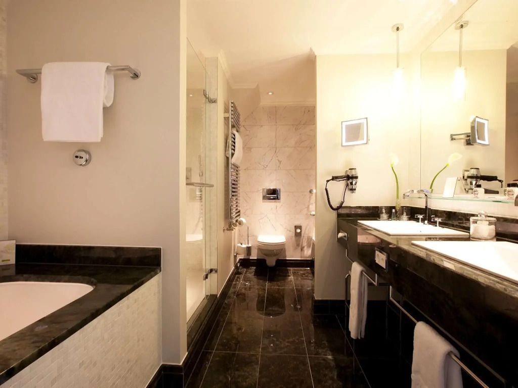 Modernes Badezimmer mit dunklem Steinboden und zwei Waschbecken