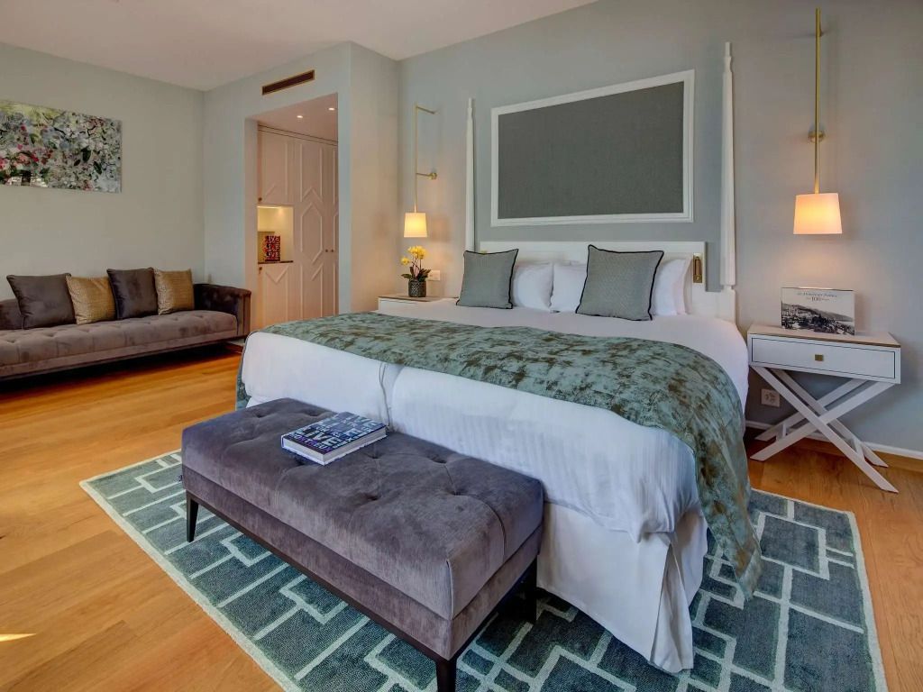 Penthouse Suite mit elegantem Doppelbett und Sitzgelegenheit