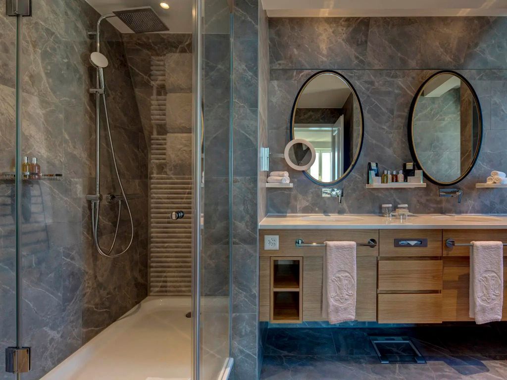 Luxuriöses Badezimmer mit großer Dusche und ovalem Spiegel