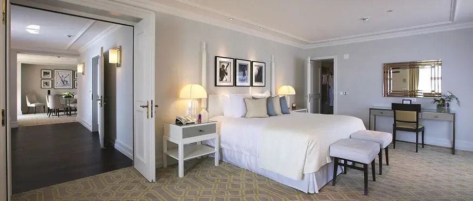 Helles Schlafzimmer mit Doppelbett und stilvoller Beleuchtung in der Quincy Jones Suite