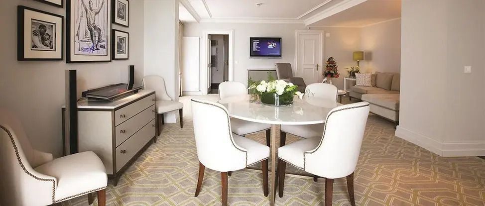Essbereich mit rundem Tisch und weißen Stühlen in der Quincy Jones Suite