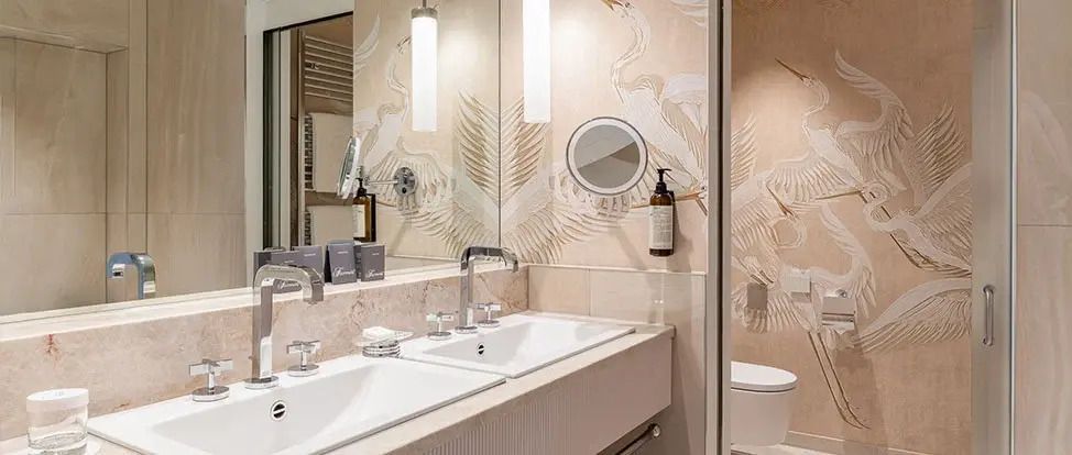 Luxuriöses Badezimmer mit Doppelwaschbecken und kunstvoller Wanddekoration.