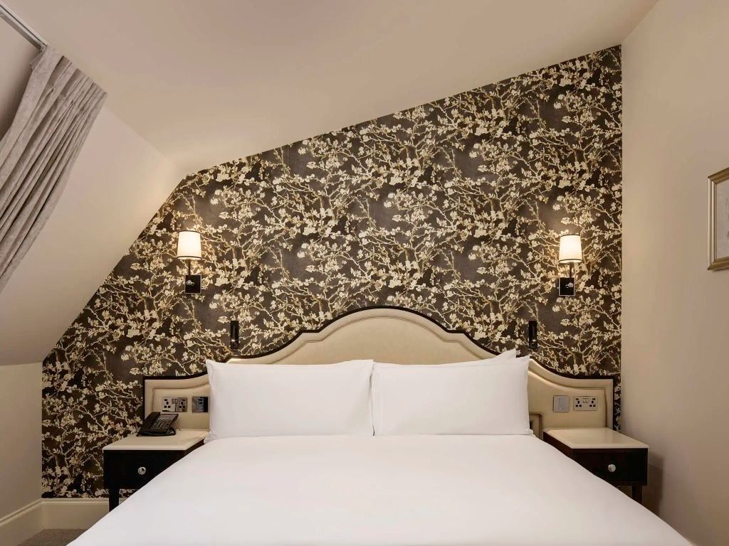Elegantes Schlafzimmer mit gemustertem Hintergrund und Doppelbett