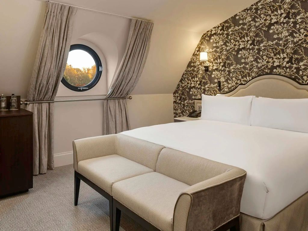 Zimmeransicht mit rundem Fenster, Doppelbett und Sitzbank