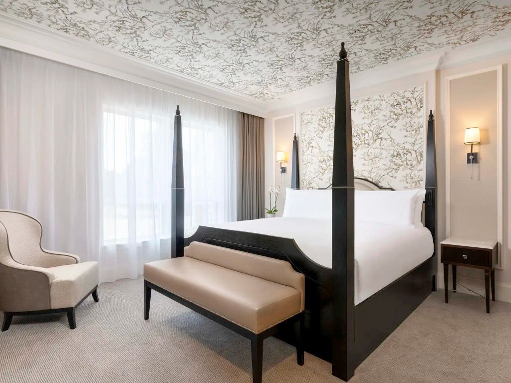 Elegantes Schlafzimmer mit Himmelbett und bodenlangen Fenstern