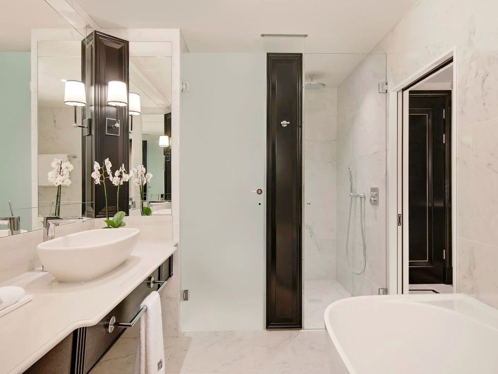 Modernes Badezimmer mit Dusche Waschbecken und großen Spiegeln
