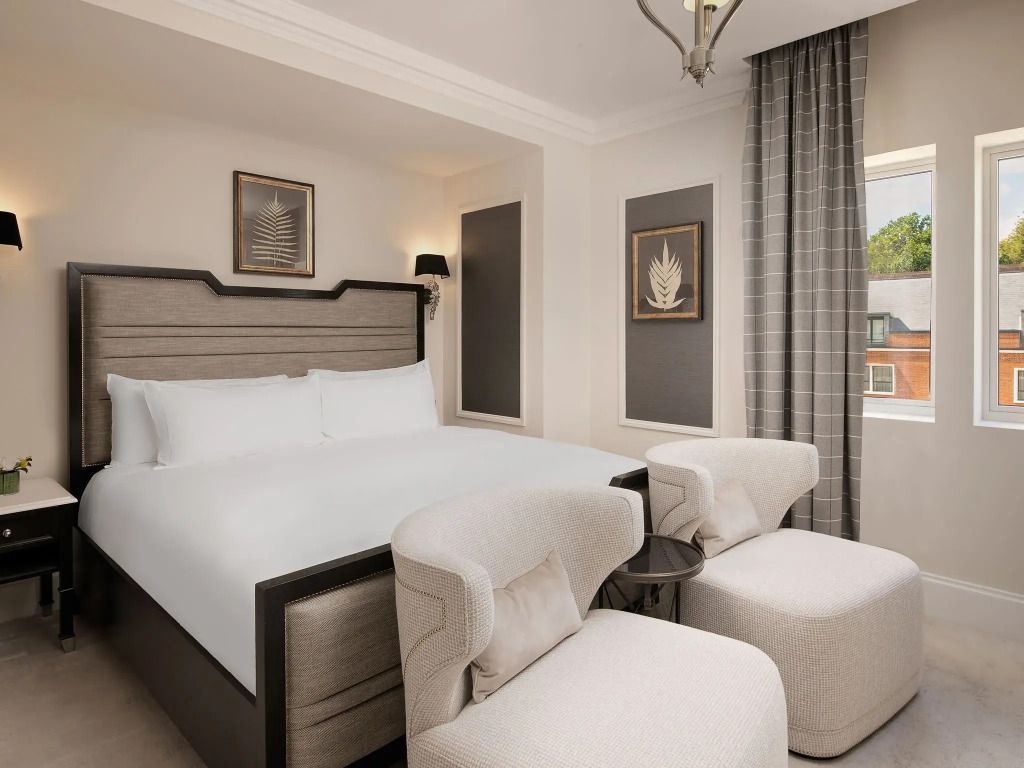 Komfortables Schlafzimmer mit Designer-Bett und gemütlichen Sesseln