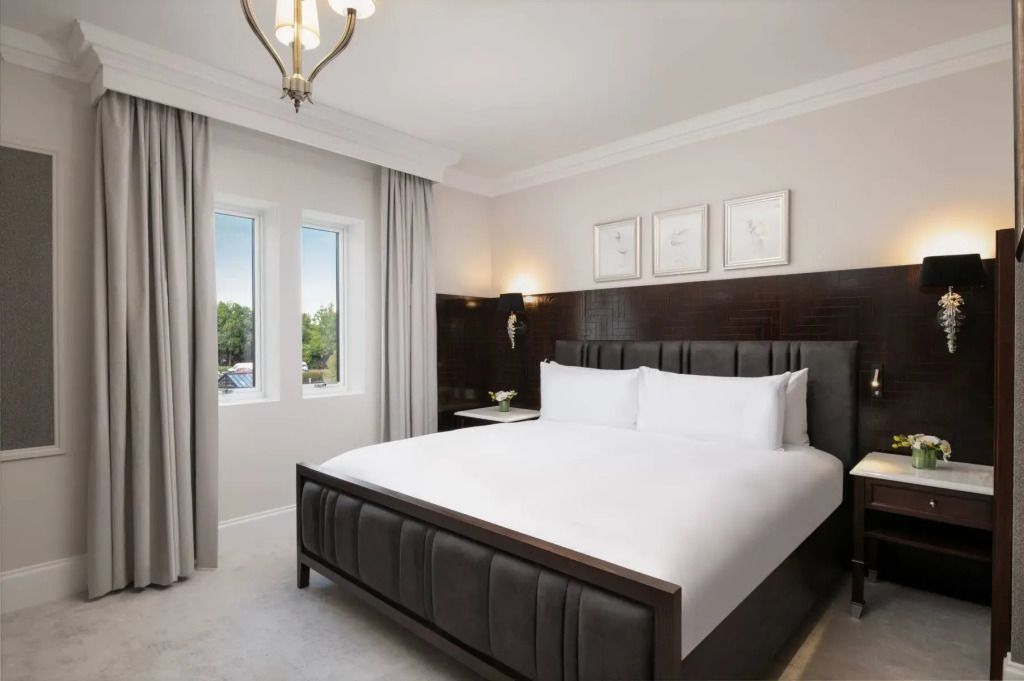 Helles Schlafzimmer mit großem Bett und eleganten Vorhängen