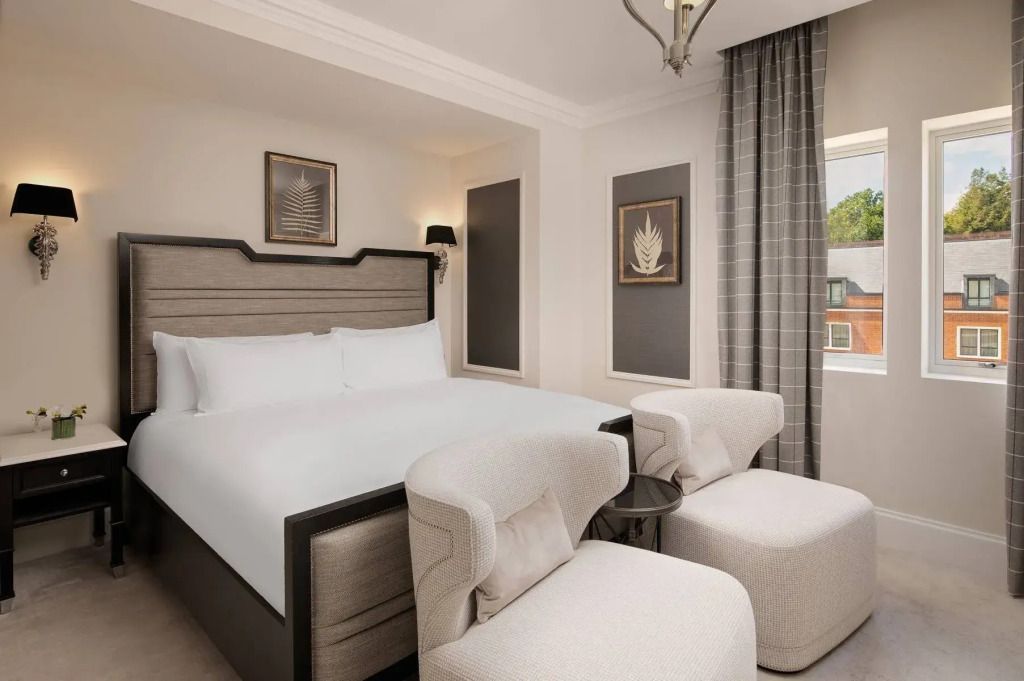 Stilvoll eingerichtetes Zimmer mit hochwertigen Sesseln und Fensterblick