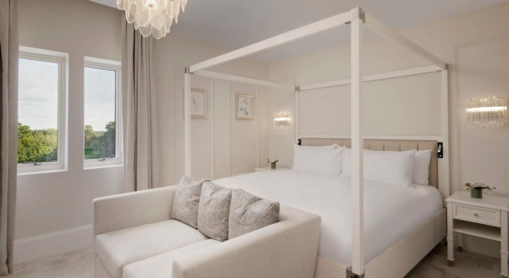 Helles Schlafzimmer mit Himmelbett und gemütlichem Sofa