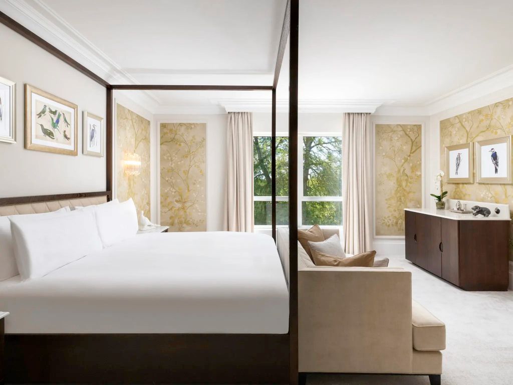 Modernes Schlafzimmer mit stilvollen Tapeten und einem großen Fenster mit Gartenblick.