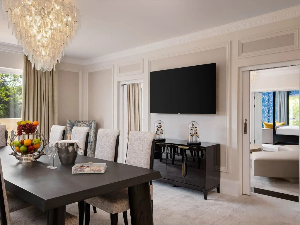 Essbereich mit großem Tisch, luxuriösen Stühlen und prächtigem Kronleuchter in der Suite.