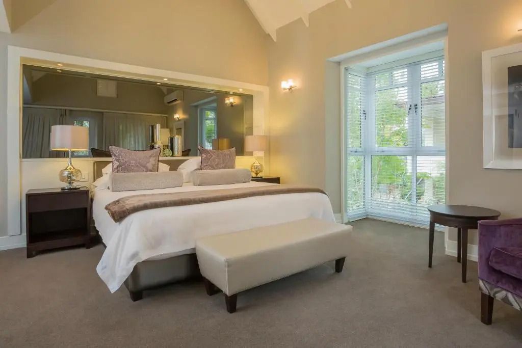 Stilvolles Schlafzimmer mit großem Fenster und eleganter Einrichtung im Fancourt Resort