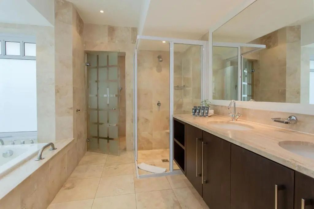 Modernes Badezimmer mit begehbarer Dusche und edlen Materialien im Fancourt Resort