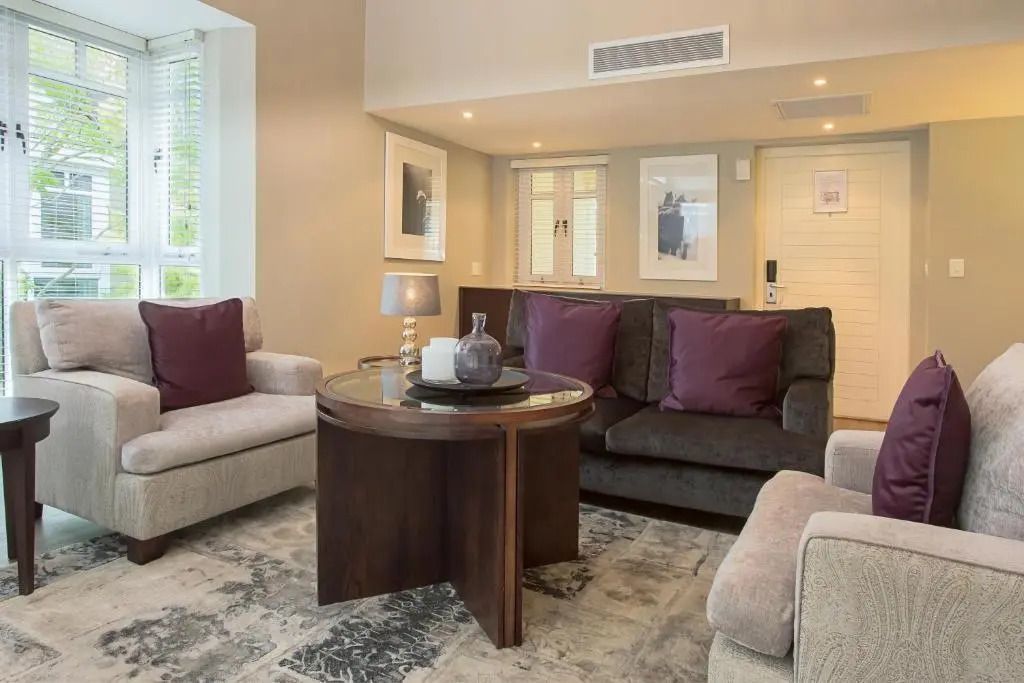 Gemütliche Wohnzimmerecke mit komfortablen Sofas und stilvollen Akzenten im Fancourt Resort