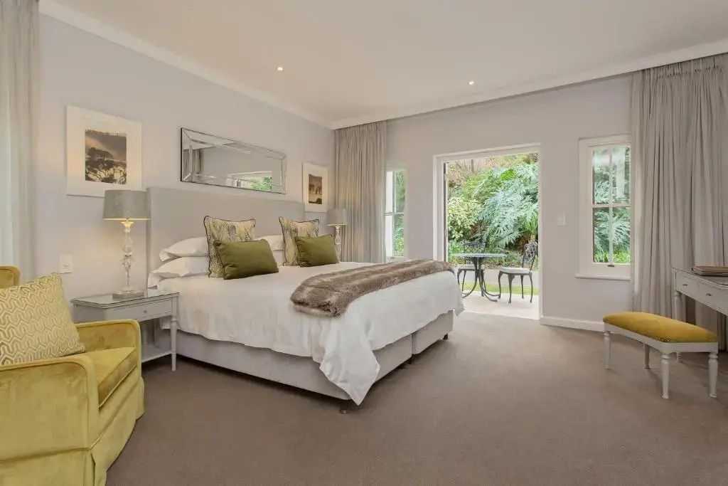 Klassisches Schlafzimmer mit Doppelbett und Zugang zum Balkon im Fancourt Resort