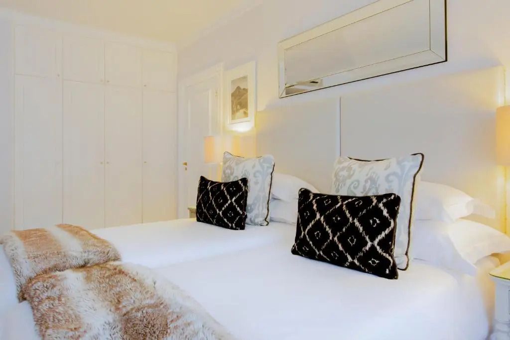 Gemütliches Einzelzimmer mit modernen Dekokissen im Fancourt Resort