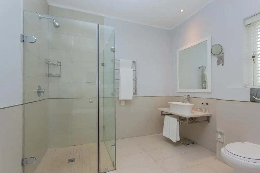 Modernes Badezimmer mit großer Glasdusche und weißen Fliesen