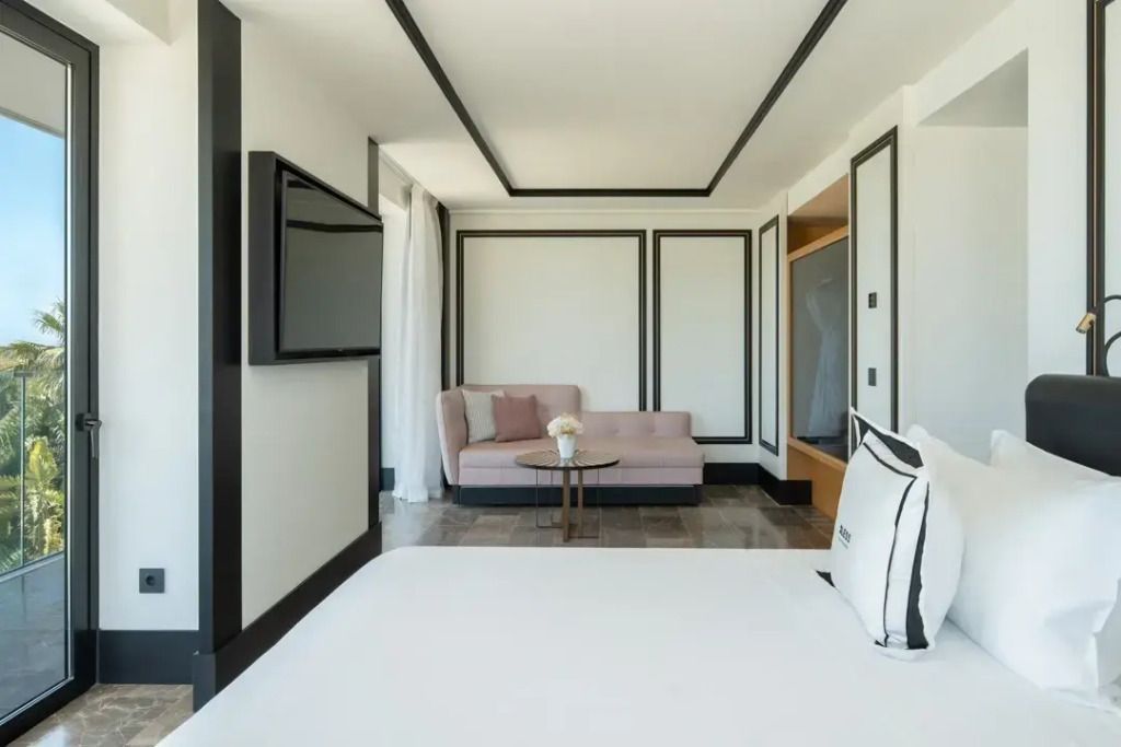 Elegante Suite mit modernem Sofa und Wandfernseher im minimalistischen Design.