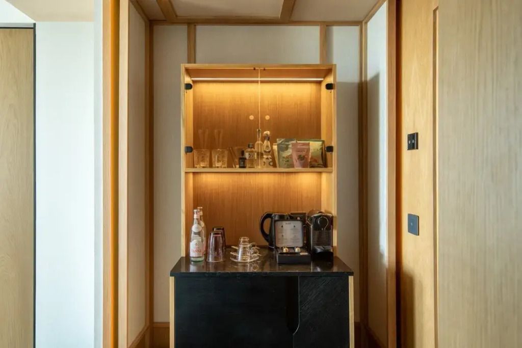 Kleine Kaffee- und Minibar mit stilvoller Beleuchtung in Holzoptik.
