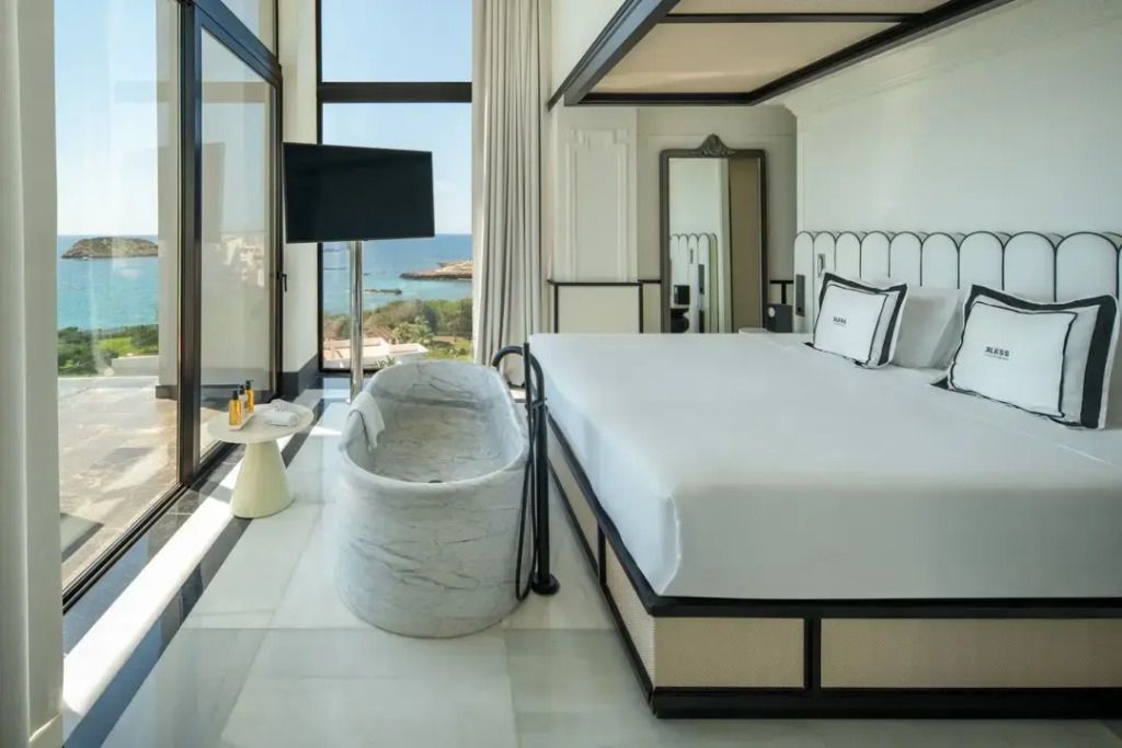Geräumige Suite mit großem Bett und Ausblick auf das Meer in Ibiza.