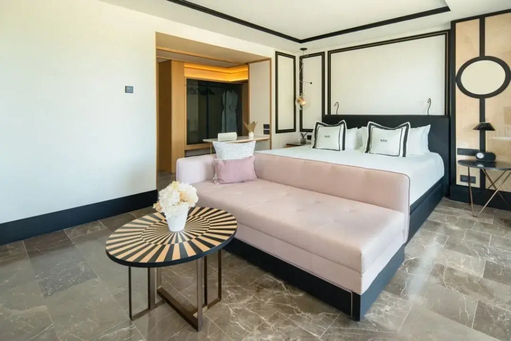 Elegantes Studio mit Doppelbett, Sofa und dekorativem Tisch in Ibiza