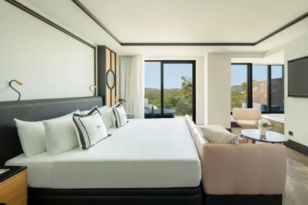 Helles Zimmer mit Doppelbett und Aussicht auf die Landschaft in Ibiza