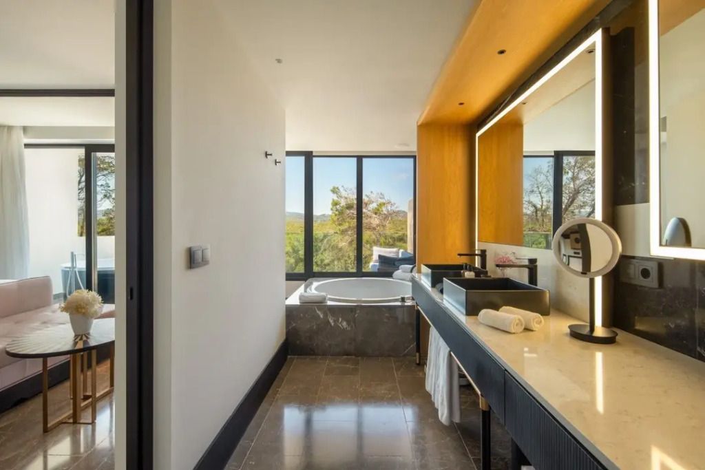 Modernes Badezimmer mit großem Spiegel und Jacuzzi mit Ausblick