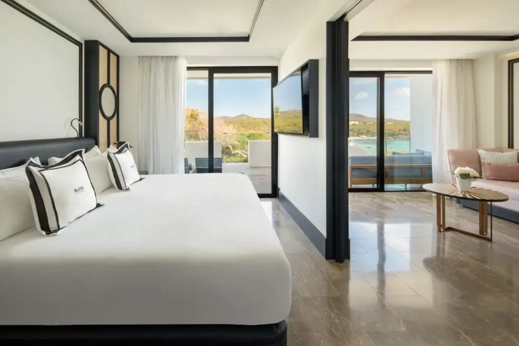 Elegantes Schlafzimmer mit Doppelbett und Zugang zur Terrasse mit Meerblick